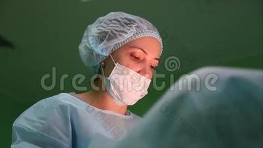 现代手术室聚焦集<strong>中外</strong>科手术的画像。 外科医生缝合